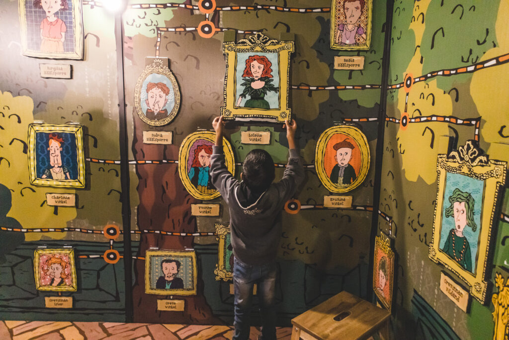 Barn som lyfter en tavla från en vägg